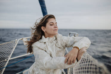 Beautiful woman with eyes closed enjoying vacation on boat - GMLF01171