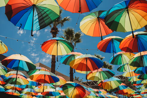 Regenbogen-Regenschirme hängen an einer Schnur - CAVF93981