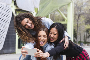 Unbekümmerte junge Freunde machen ein Selfie mit dem Handy - PNAF01441