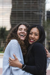 Cheerful female friends embracing each other - PNAF01445