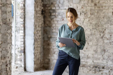 Female architect using digital tablet at construction site - PESF02761