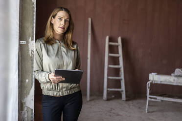 Female architect with digital tablet at construction site - PESF02796