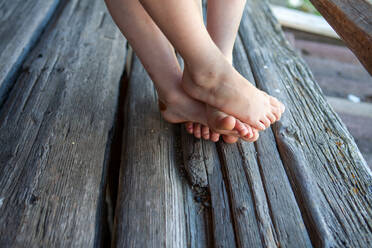 Leg's of girls on wooden bench - GAF00186