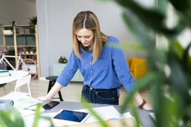 Blonde Geschäftsfrau mit digitalem Tablet im Büro - GIOF12470