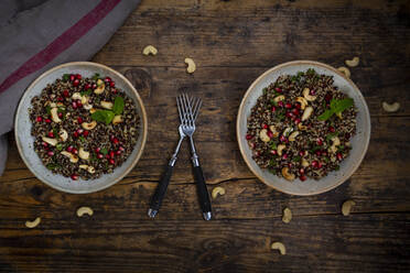 Two bowls of vegan quinoa salad with cashews, pomegranate seeds and mint - LVF09141