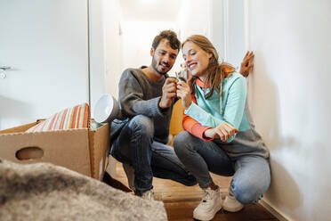 Happy young couple holding key at new home - JOSEF04070