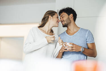 Young couple rubbing noses in kitchen at home - JOSEF04123