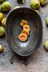 Green fig slices in modern black bowl on the table with grunge texture. minimal concept food. Also known as ripe white figs - ADSF22910