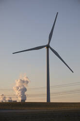 Germany, North Rhine Westphalia, Neurath, Wind turbine with lignite power station in background - JATF01302
