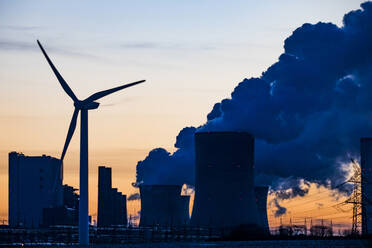 Germany, North Rhine Westphalia, Niederaussem, Wind turbine with lignite power station in background - JATF01308