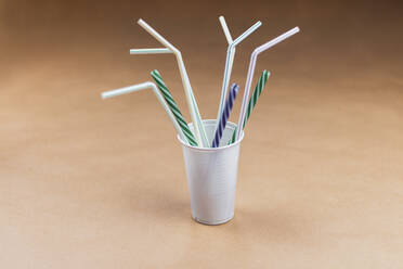 Studio shot of plastic cup with various drinking straws - MMAF01428