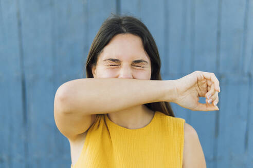 Young woman with eyes closed covering mouth with hand - MIMFF00704