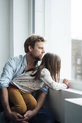 Mature man and girl looking through window at home - JOSEF04145