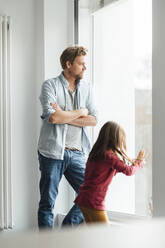 Vater und Tochter stehen am Fenster zu Hause - JOSEF04184