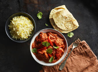 Studioaufnahme einer Schüssel mit Chicken Tikka, einer Schüssel mit Basmatireis und Naan-Brot - KSWF02205