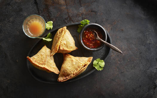 Tablett mit Samosa-Knödeln, Schale mit Chilisauce und Glas Chai-Tee - KSWF02207