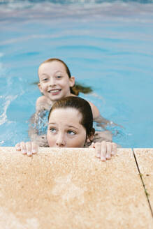 Siblings playing in swimming pool together - AGGF00100