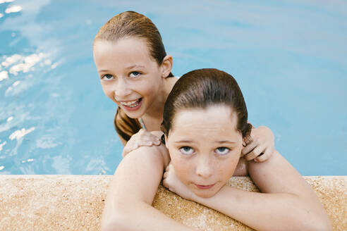 Smiling sister with brother in swimming pool - AGGF00102