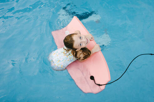 Girl playing with swimming float in water - AGGF00105