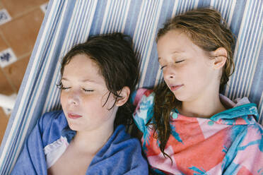 Bruder und Schwester im Bademantel schlafen in der Hängematte - AGGF00107