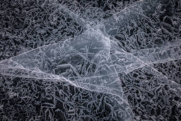 Von oben auf die gefrorene Oberfläche des Baikalsees mit chaotischen Mustern und Rissen als abstrakter Hintergrund - ADSF23043