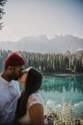 Junges Paar küsst sich am Karersee in Südtirol, Italien - MJRF00385