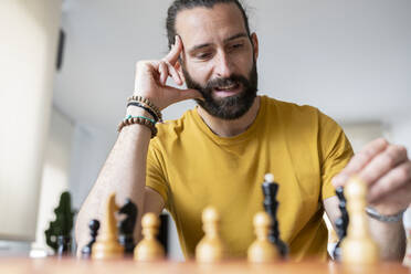 Mann mit Kopf in der Hand spielt Schach zu Hause - JCCMF01953