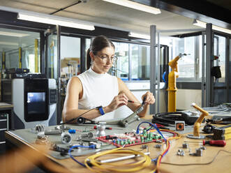 Female engineer working with electrical component in industry - CVF01746