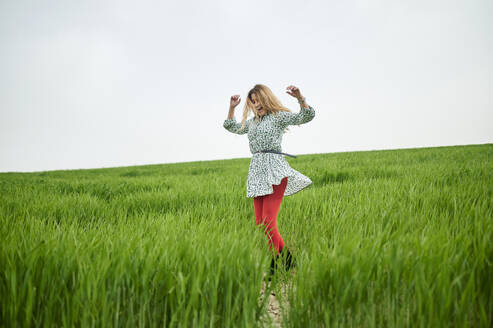 Happy woman dancing at meadow - KIJF03740