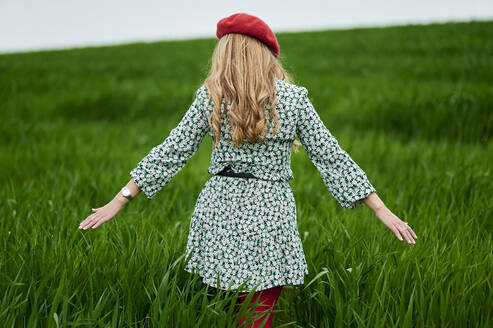 Mid adult woman wearing floral pattern at meadow - KIJF03753