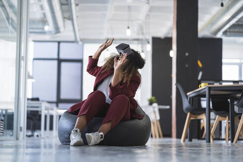 Businesswoman gesturing while using virtual reality simulator in office - SNF01260