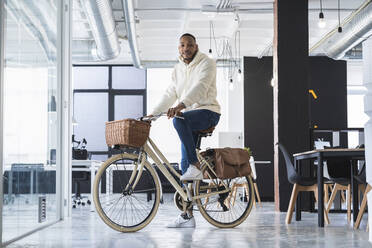 Geschäftsmann auf dem Fahrrad im Coworking-Büro - SNF01274