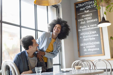 Man looking at cheerful girlfriend in cafe - EIF00853