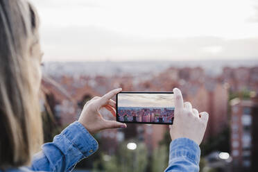 Frau fotografiert Stadtbild bei Sonnenuntergang - EBBF03397