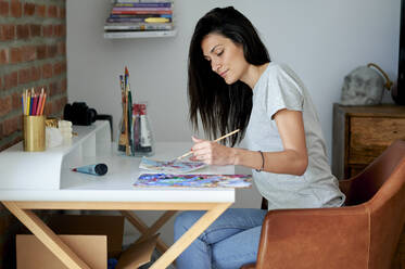 Creative woman painting at home - KIJF03800