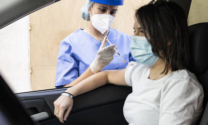 Frau erhält COVID-19-Impfstoff im Auto am Drive-In - JCCMF01992