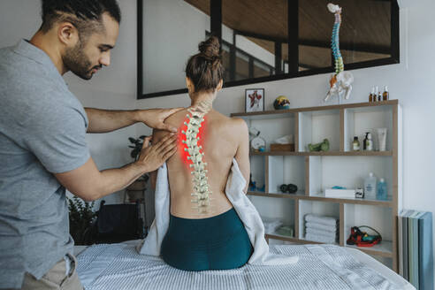 Physiotherapist treating female patient's bent spine - LIFIF00019