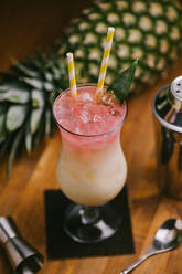 From above composition of sweet classic Pina Colada cocktails served on bar counter near shaker and jigger - ADSF23137