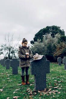 Kleiner Junge trauert auf dem Friedhof um einen im Krieg gefallenen Soldaten - ADSF23146