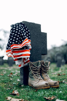 Amerikanische Nationalflagge und Armeeflagge auf dem Grabstein eines Soldatenfriedhofs an einem frühen Herbsttag - ADSF23151