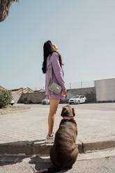 Mittlere erwachsene Frau mit Haushund auf dem Fußweg stehend - AFVF08645