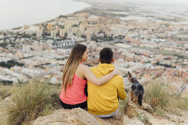 Couple sitting by dog on hill - MIMFF00720