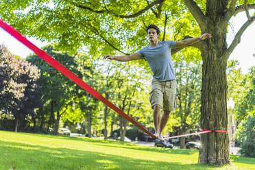 Sportlicher Mann beim Versuch einer Slackline - CAVF94004