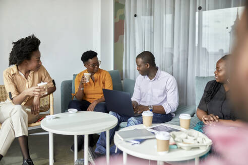 Männliche und weibliche Unternehmer unterhalten sich bei einem Kaffee im Coworking-Büro - ZEDF04053