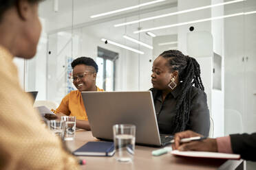 Unternehmerinnen sitzen während einer Besprechung in einem Coworking-Büro am Schreibtisch - ZEDF04059