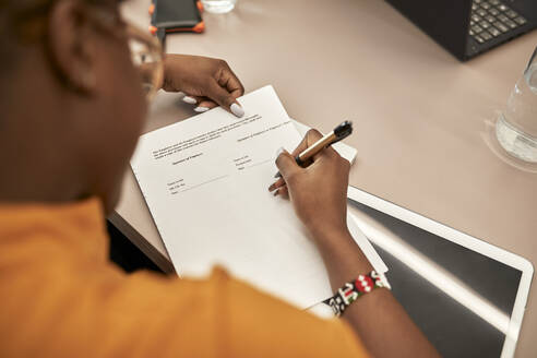 Businesswoman signing contract at desk in office - ZEDF04061