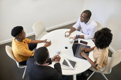 Männliche und weibliche Unternehmer diskutieren während einer Konferenz im Coworking-Büro - ZEDF04119