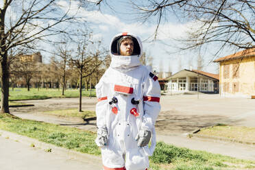 Male astronaut looking away while standing outdoors during sunny day - MEUF02368