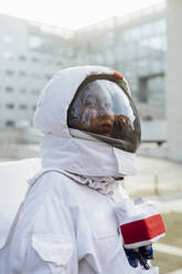 Weibliche Astronautin im Raumanzug schaut in der Stadt weg - MEUF02410