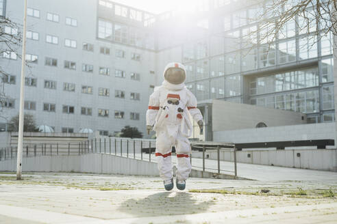 Astronautin in der Luft auf einem Fußweg an einem sonnigen Tag - MEUF02423